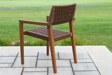 Load image into Gallery viewer, Brown wicker chair on a patio with grass and flowers in the background