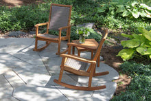 Load image into Gallery viewer, Two wooden rocking chairs on a stone patio with a small table