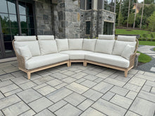 Load image into Gallery viewer, Sectional outdoor sofa with beige cushions on a stone patio.