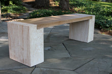 Load image into Gallery viewer, Wooden bench on a stone patio with greenery in the background