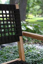 Load image into Gallery viewer, Chair with black woven seat and backrest in a garden setting