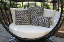 Load image into Gallery viewer, Wicker spherical chair with white cushions and patterned gray pillows on a patio.