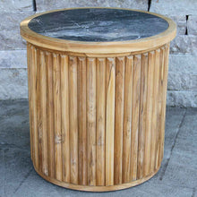 Load image into Gallery viewer, Wooden side table with a dark stone top against a stone wall background