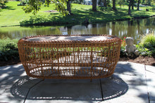 Load image into Gallery viewer, Wicker table on a patio with a pond and garden in the background