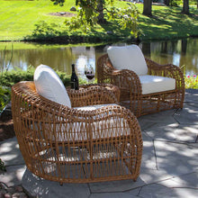 Load image into Gallery viewer, Wicker chairs with white cushions on a patio by a pond