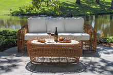 Load image into Gallery viewer, Outdoor patio set with wicker furniture and a table by a pond