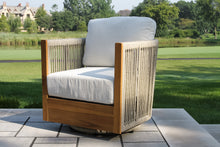 Load image into Gallery viewer, Wooden outdoor chair with white cushion on a patio with green grass and trees in the background