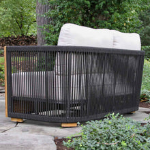 Load image into Gallery viewer, Black wicker outdoor love seat with white cushions in a garden setting