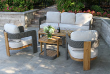 Load image into Gallery viewer, Outdoor patio furniture set with beige cushions on a stone patio.