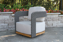 Load image into Gallery viewer, Outdoor chair with white cushions and gray woven armrests on a patio.