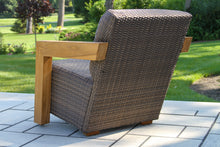 Load image into Gallery viewer, Wicker chair with wooden armrest on a patio
