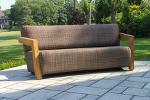 Load image into Gallery viewer, Brown wicker outdoor sofa on a patio