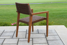 Load image into Gallery viewer, Brown wicker chair on a stone patio with grass in the background
