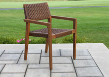 Load image into Gallery viewer, Wooden chair with woven seat on a patio with grass in the background
