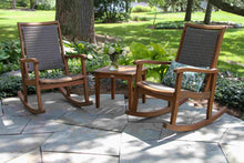 Load image into Gallery viewer, Two wooden rocking chairs on a stone patio with a garden background
