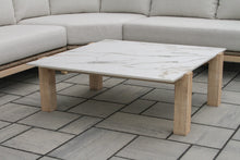 Load image into Gallery viewer, Wooden coffee table on a tiled patio with a gray sectional sofa in the background
