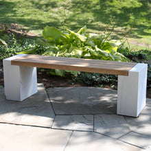 Load image into Gallery viewer, Modern outdoor bench with wooden seat and white marble-like base in a garden setting.
