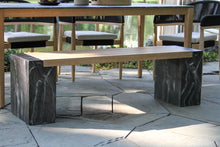 Load image into Gallery viewer, Outdoor patio setting with a wooden bench and stone bases on a paved area.

