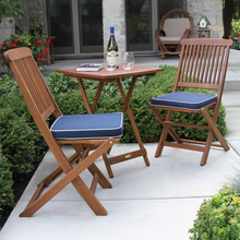 Load image into Gallery viewer, Wooden outdoor furniture set with blue cushions on a patio
