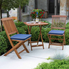 Load image into Gallery viewer, Outdoor patio set with wooden chairs and table on a patio with plants and flowers.
