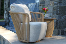 Load image into Gallery viewer, Wicker chair with cushioned seat and backrest in an outdoor setting.
