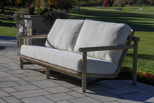 Load image into Gallery viewer, Outdoor sofa with white cushions on a patio area with grass and trees in the background

