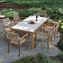 Load image into Gallery viewer, Outdoor dining table set with chairs on a stone patio
