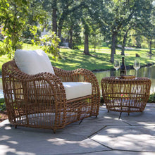 Load image into Gallery viewer, Wicker outdoor furniture set with a table and chairs on a patio.
