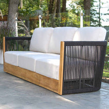 Load image into Gallery viewer, Outdoor sofa with black wicker frame and white cushions on a patio
