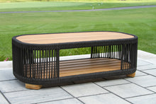Load image into Gallery viewer, Outdoor coffee table with black wicker frame and wooden top on a patio
