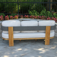 Load image into Gallery viewer, Outdoor sofa made from tires with wooden frame and white cushions, set against a garden backdrop.
