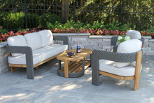 Load image into Gallery viewer, Outdoor patio furniture set with white cushions on a stone patio.
