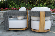 Load image into Gallery viewer, Two modern outdoor chairs with white cushions, gray woven backs, and wooden frames on a patio.
