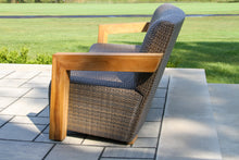Load image into Gallery viewer, Wicker sofa with wooden armrest on a patio
