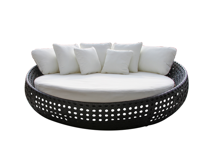 Black wicker daybed with white acrylic fabric and multiple white throw pillows